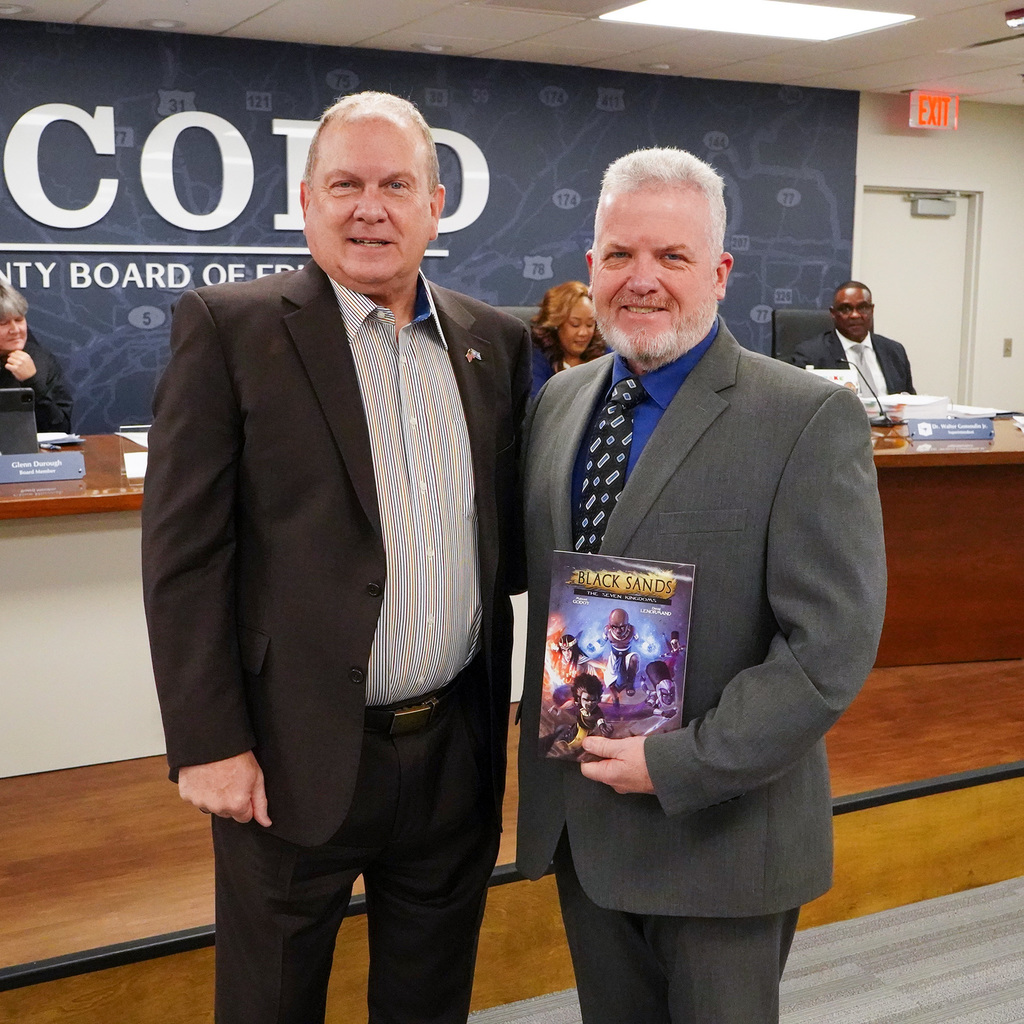 Board President Ronnie Dixon is presented with a book in his honor to be placed at Clay-Chalkville Middle School