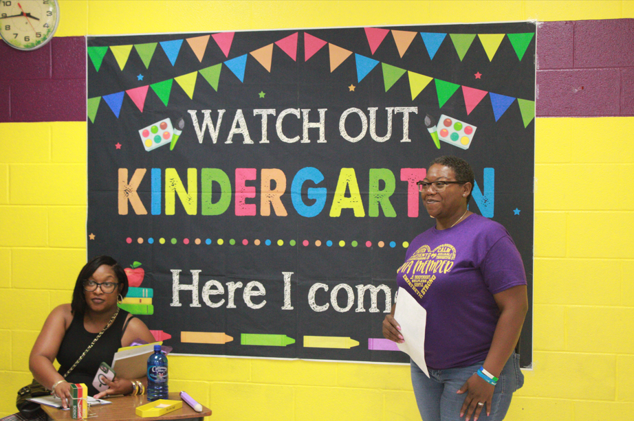 Two women pictured in front of a sign that says "Watch Out Kindergarten Here I come"