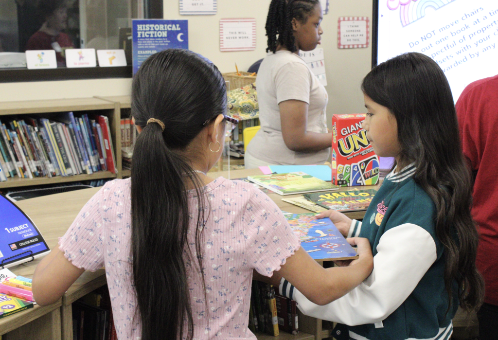 A group of students stand inside a library.