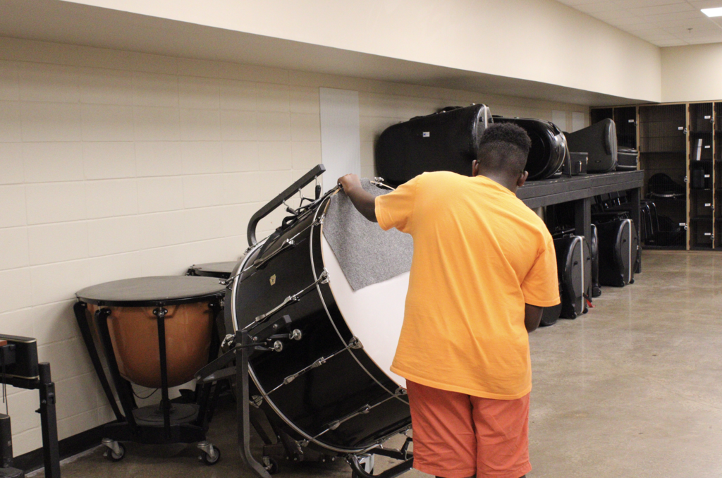 A student plays a large drum.