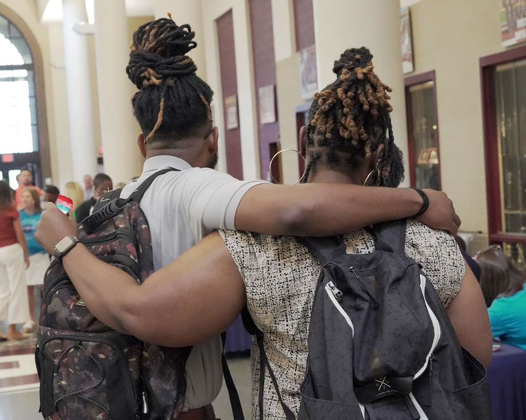 Two educators giving each other a hug across the shoulders.