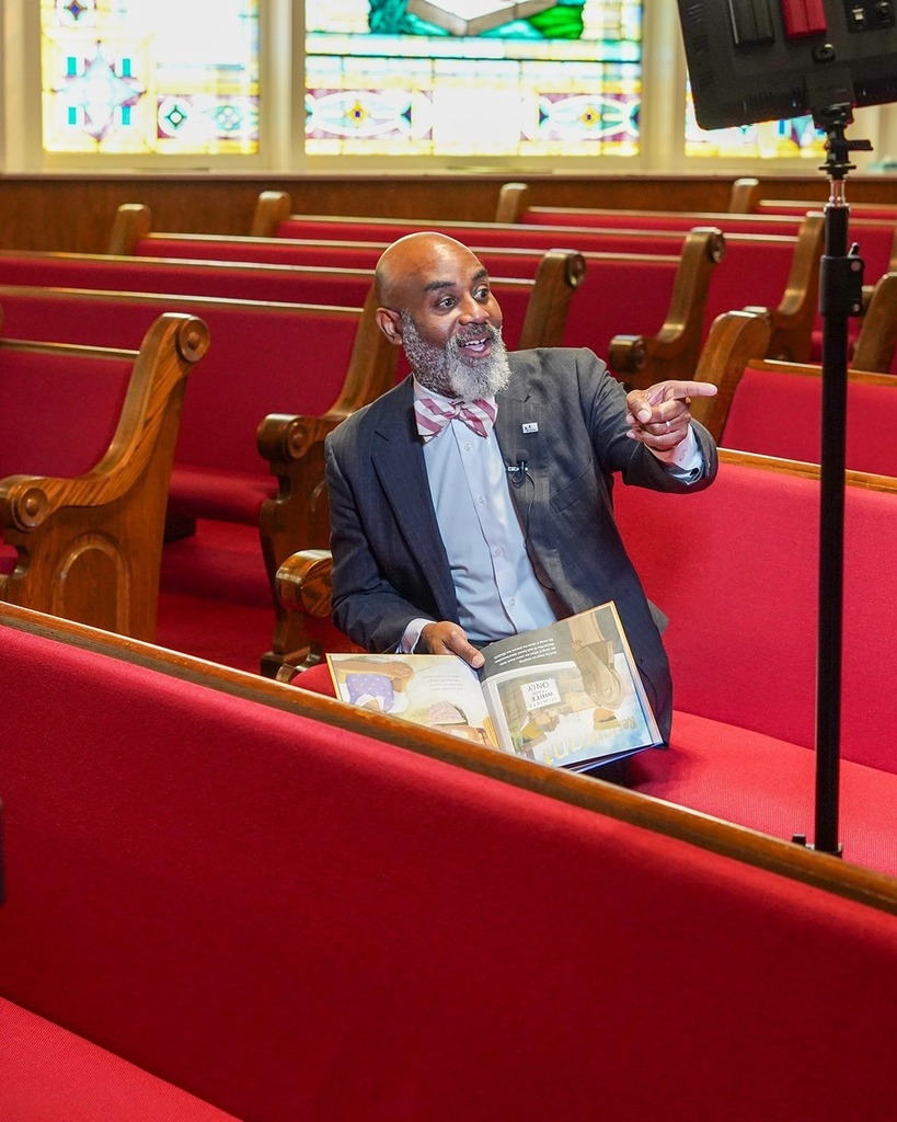 Dr. Terrence Brown is being filmed while reading a book in the 16th Street Baptist Church in Birmingham, AL. 