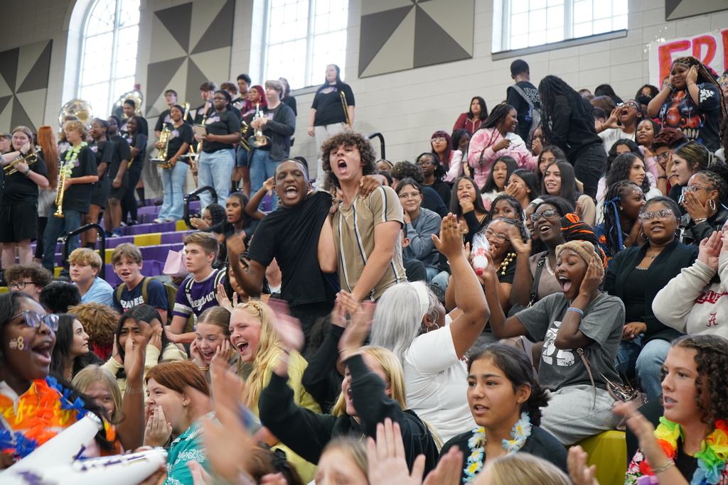 Students scream while sitting and standing in bleachers. 