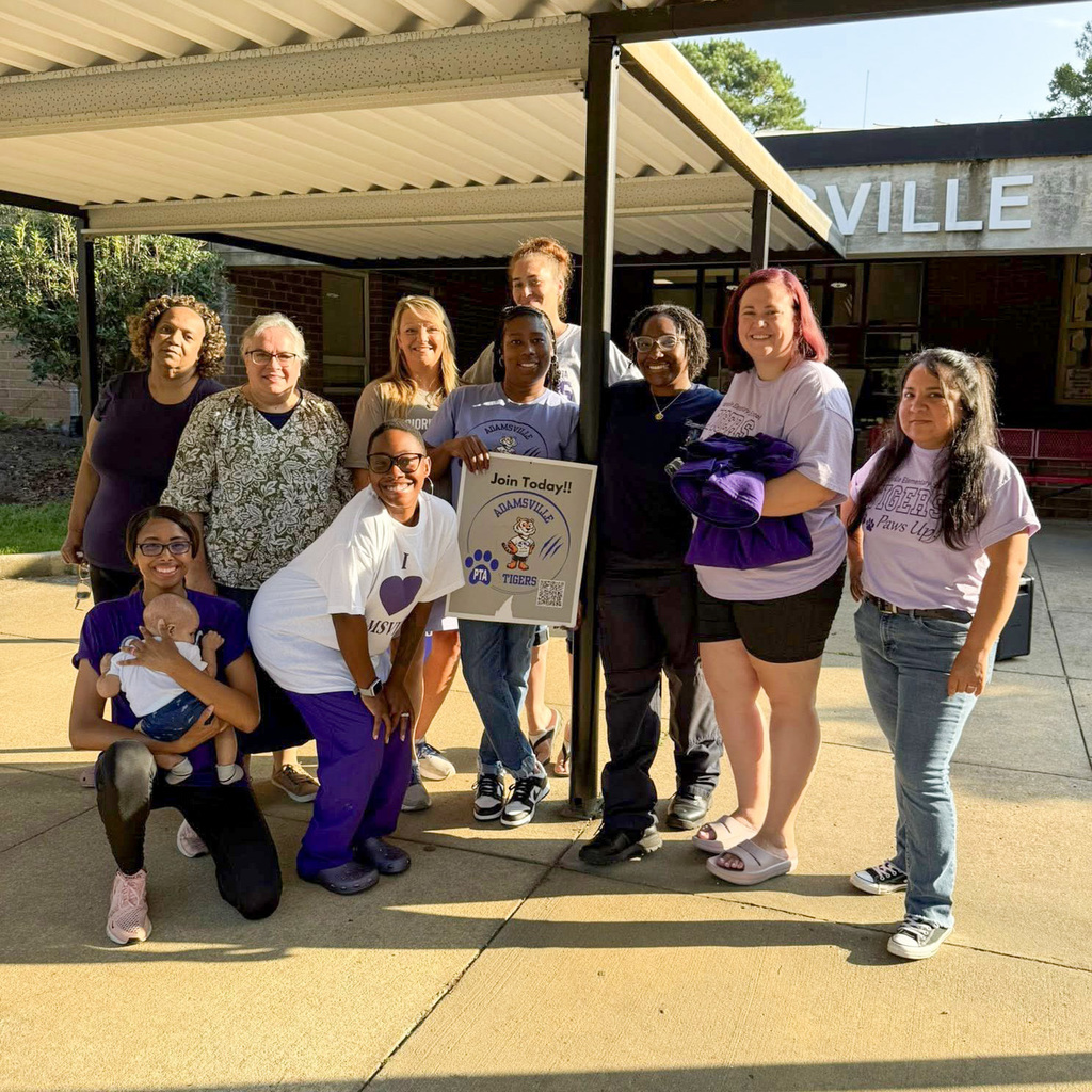 Moms of Adamsville Elementary pose for a picture outside of the school after greeting students in car line.