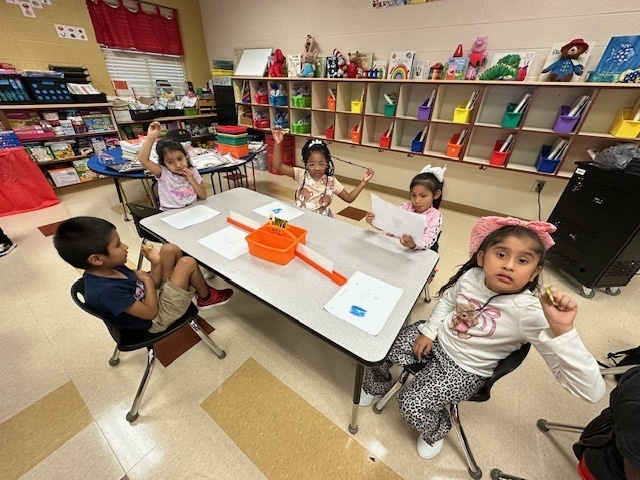 students sitting and holding kiwis