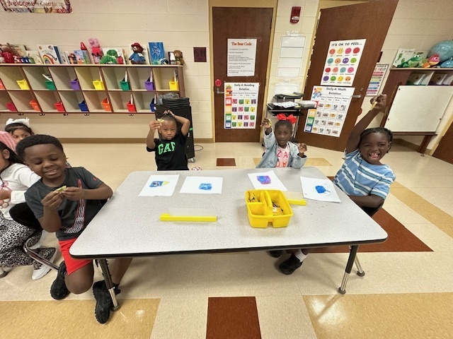 students sitting and holding kiwis