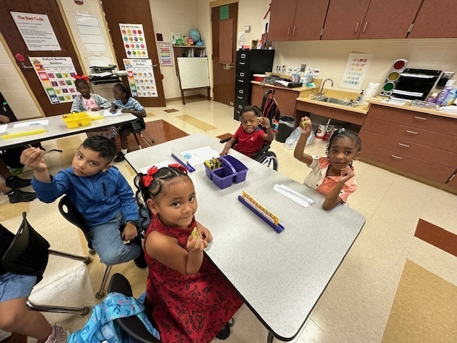 students sitting and holding kiwis