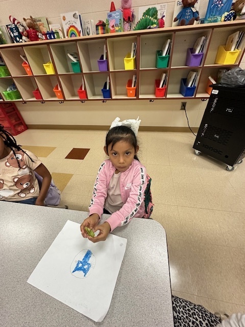 students sitting and holding kiwis