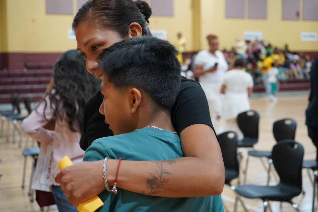 A woman and a little boy hug