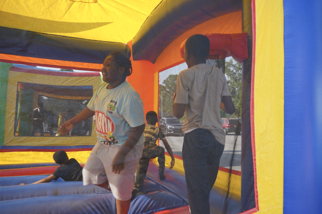 Boys smile while playing in a bounce house