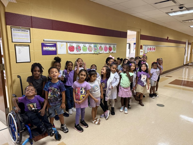 students smiling and wearing purple clothes