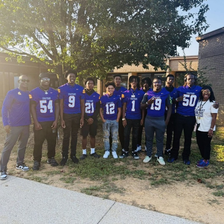 A group of high school football players posing for a picture.