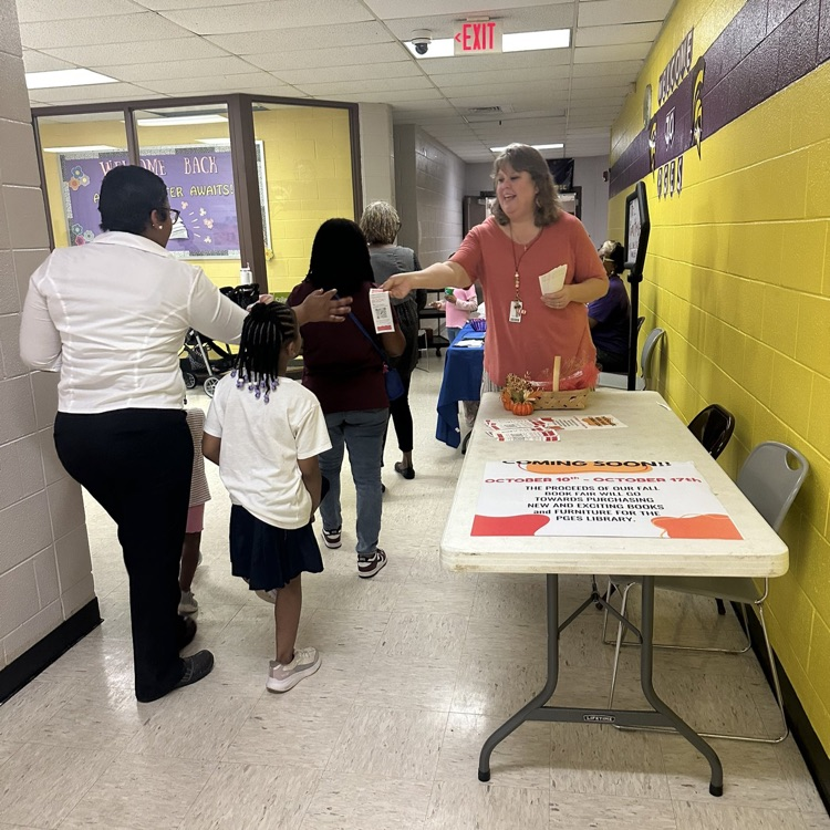 Mrs. Berry is handing out flyers telling about the upcoming Book Fair.