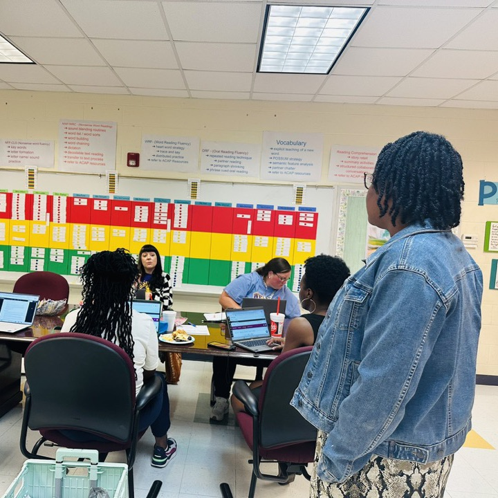 The 5th grade teachers are sitting at a table talking about their students' data.