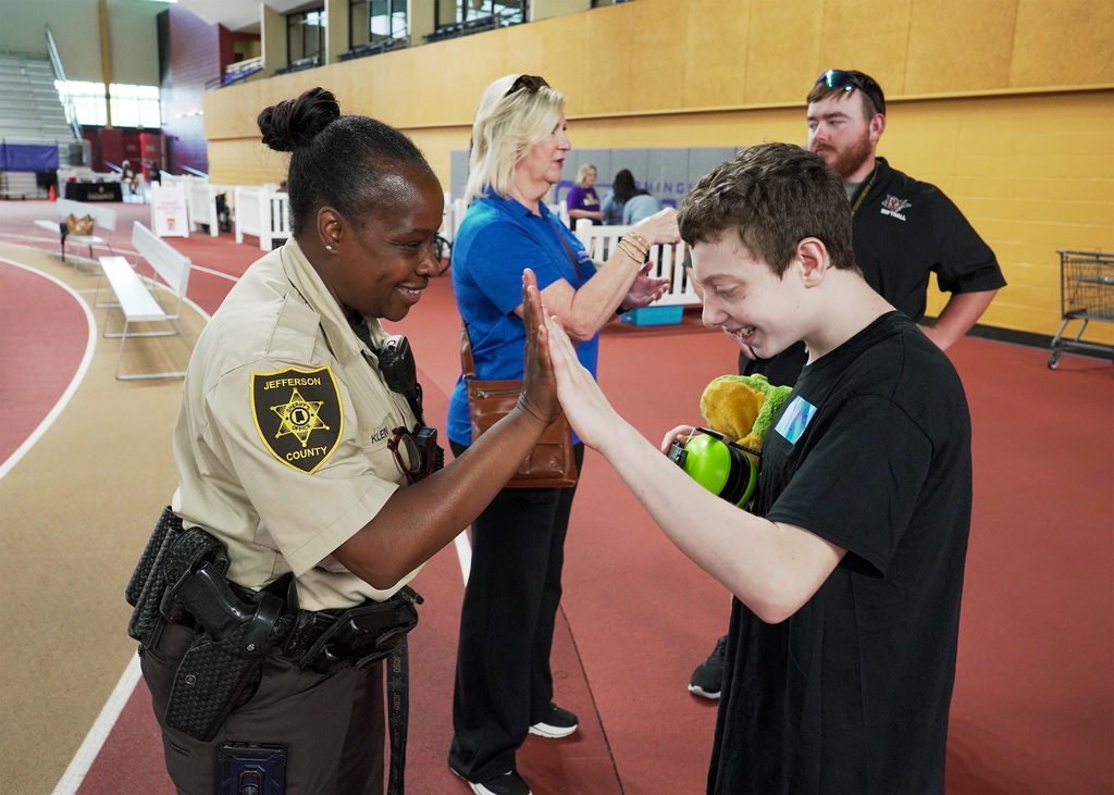 A school resource office gives a student a high five. 