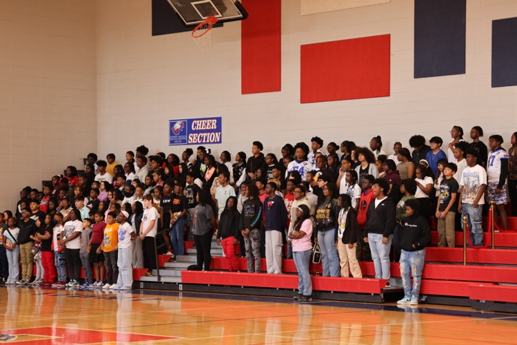 ACAP achieving student standing on the bleachers