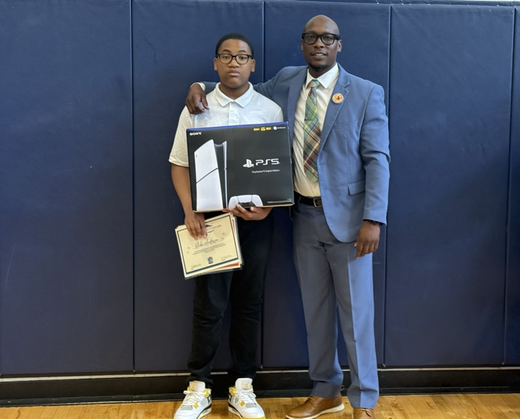top achieving student with the PS5 that he won posing with Dr. Jones