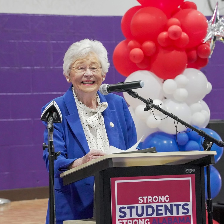 Gov. Kay Ivey standing at the podium. 