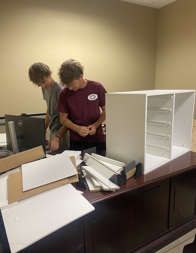 Office Aides assembling a cabinet 