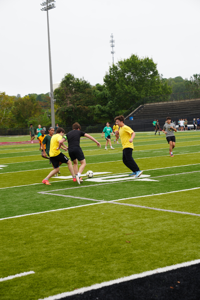 Students play soccer on a field.