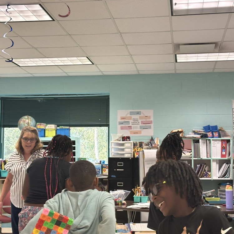 Students learning a Math lesson from Ms. Eaton while using manipulatives.