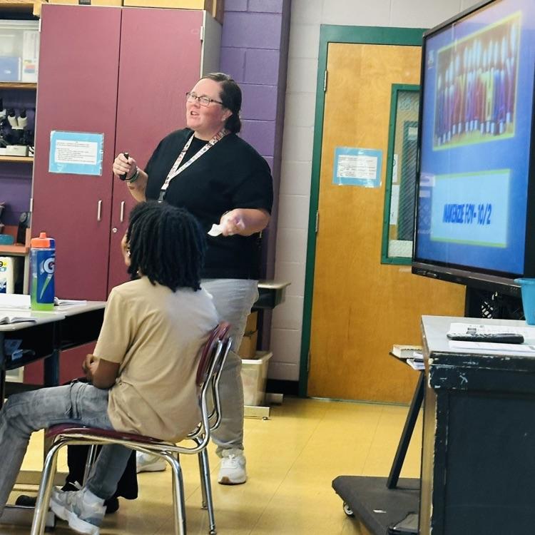 Ms. Hayes discussing the steps the students will use for the Science experiment.