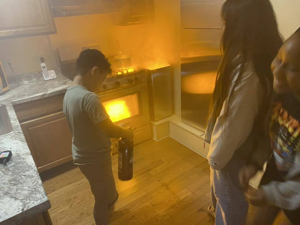 A student holds a fire extinguisher during a fire silmulation.