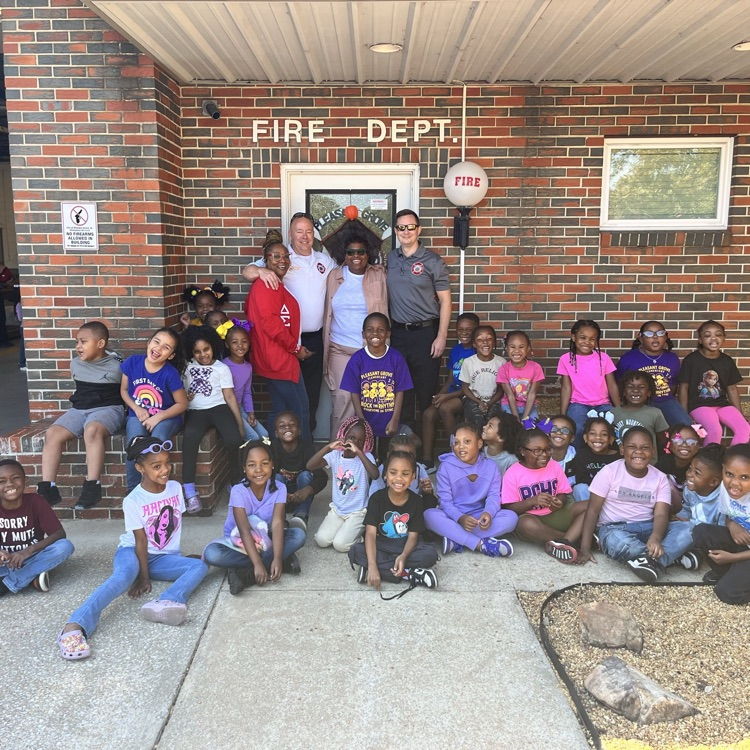 Students sitting in front of the fire house front door.