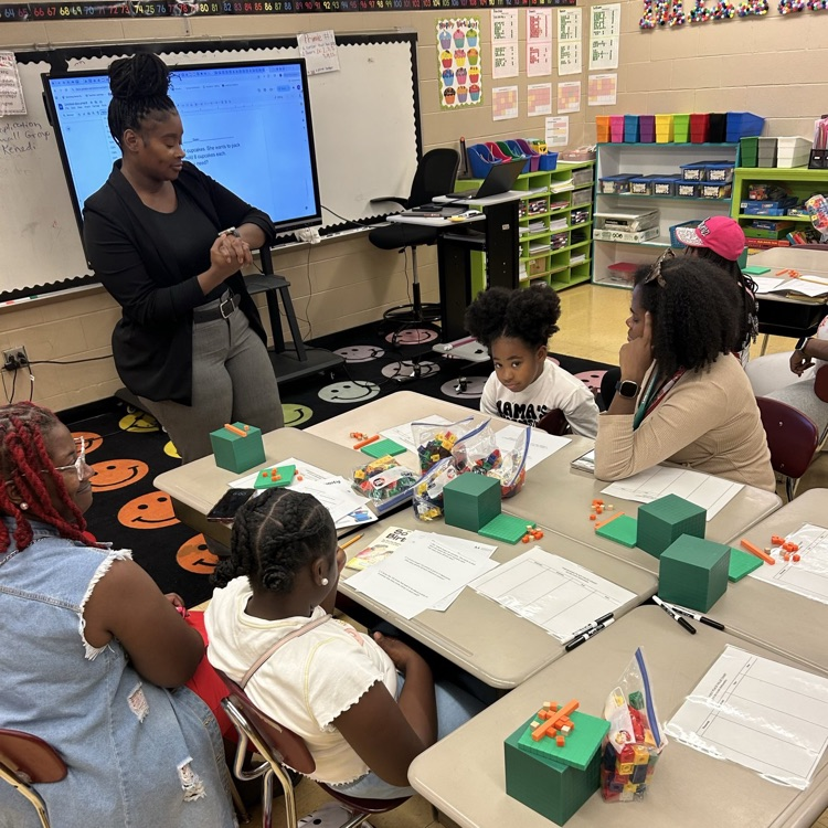 Ms. Barnfield teaching a math lesson to parents and their children.