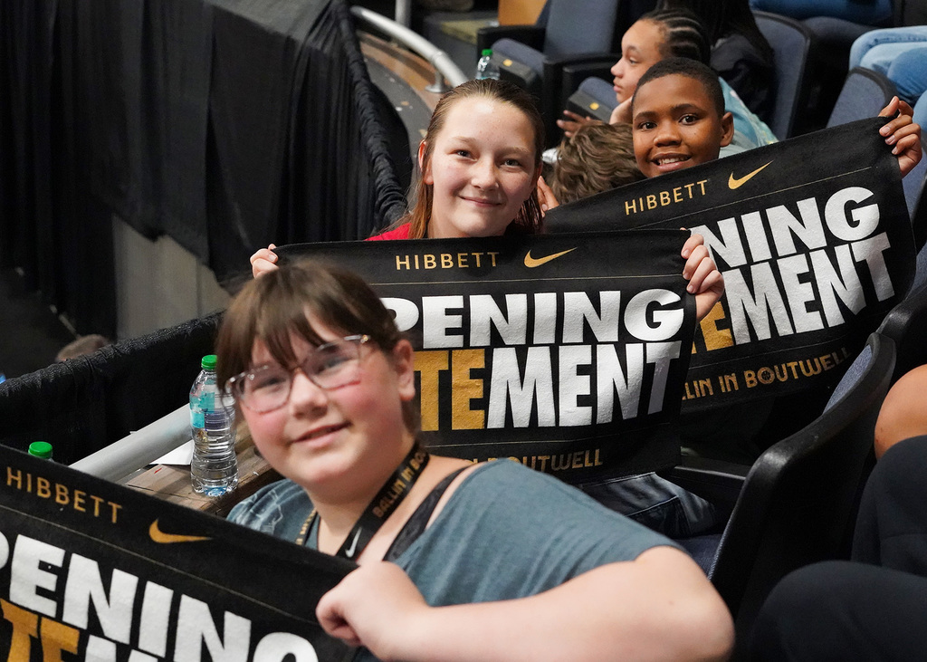 Three students holdup towels that say Hibbett, Opening STATEment, Ballin' at Boutwell.