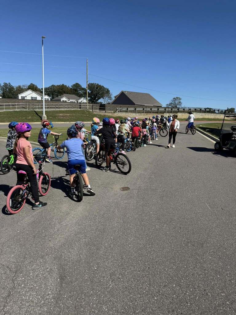 Students stand on a road with bicycles.