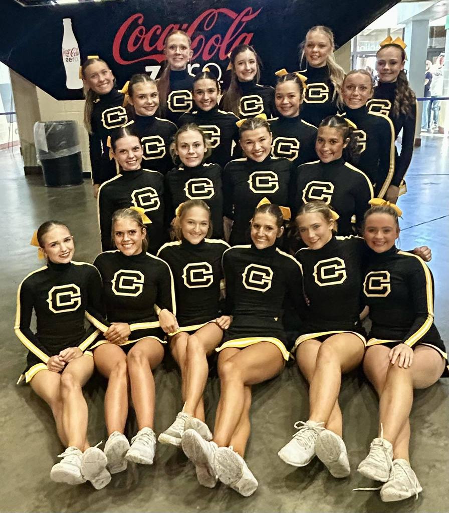 Corner High School cheerleaders stand and sit together for a photo.