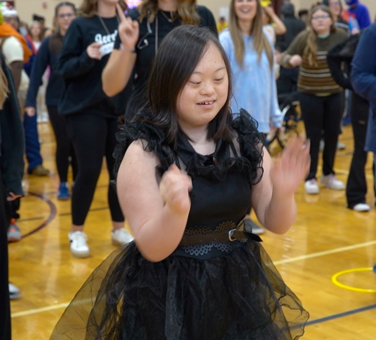 A student dances in a school gym  
