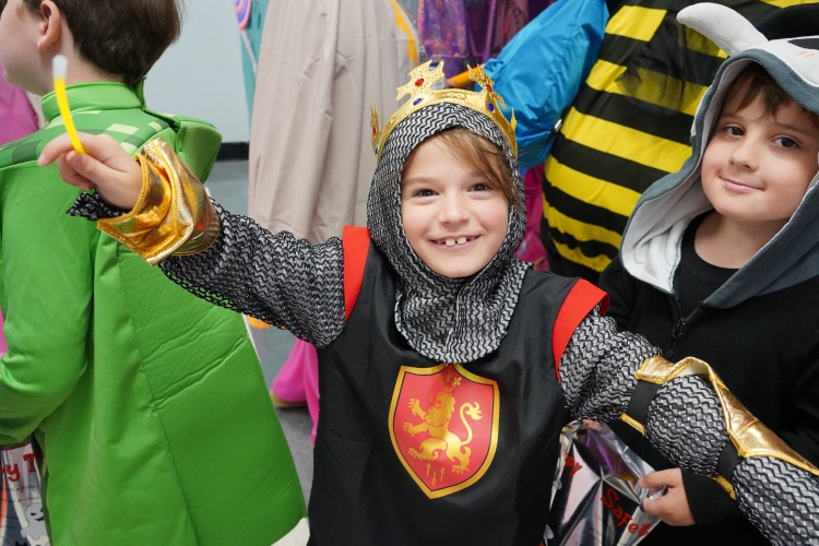 A child wearing a knight costume smiles