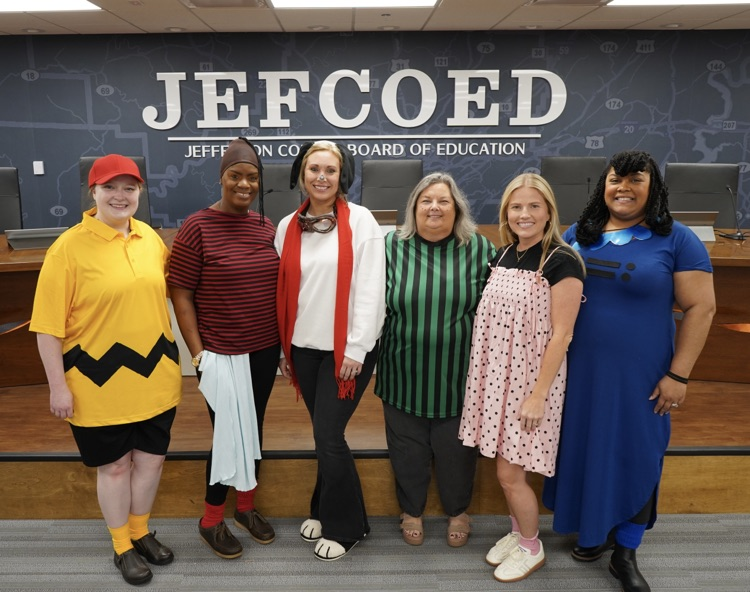 A group of JEFCOED board employees stand together for a photo. They’re wearing Charlie Brown themed costumes  