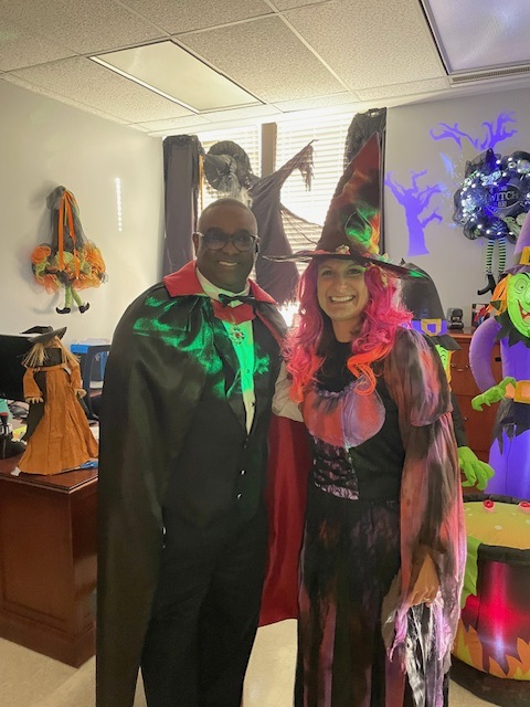 Dr. Gonsoulin and Ms. Stricklin stand together for a photo. Dr. Gonsoulin is wearing a Dracula costume and Ms. Stricklin is wearing a witch costume.