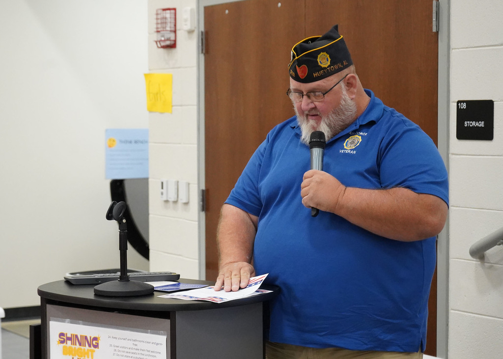A veteran speaks at a podium during a Veterans day ceremony. 