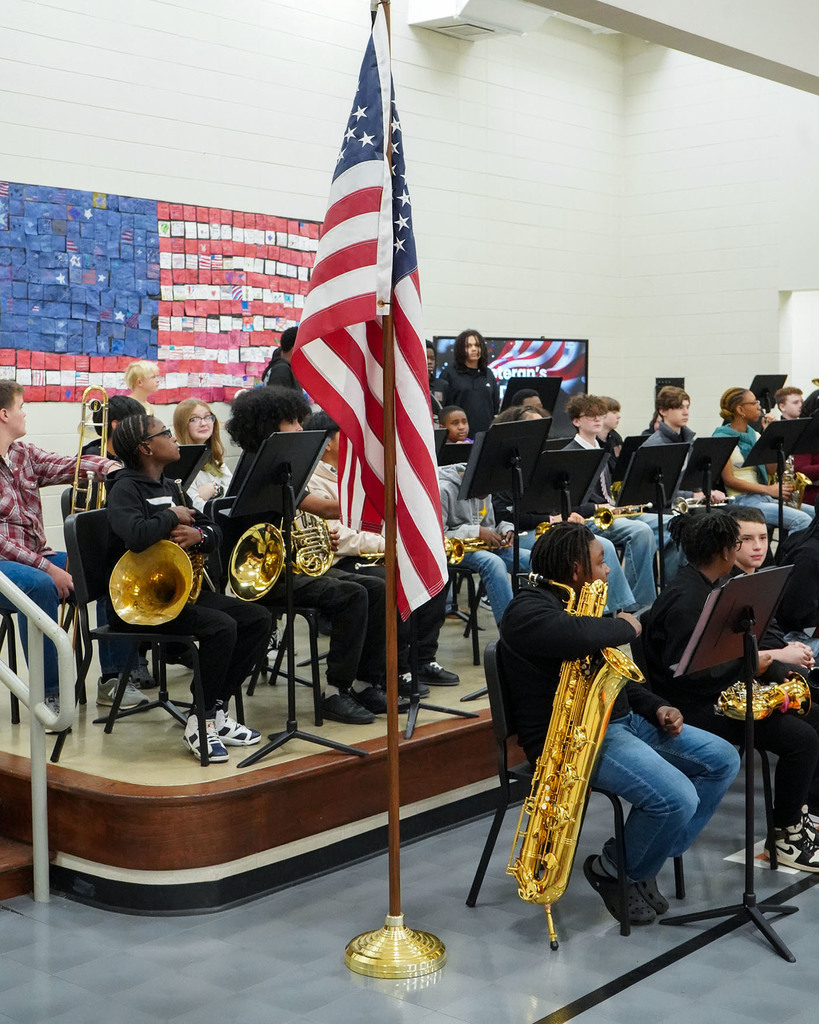 A picture of the American flag in front of a group of band members. 