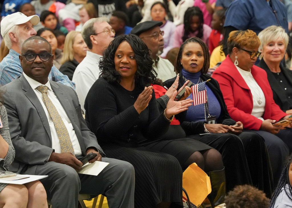 Audience members clap during a Veterans Day program. 