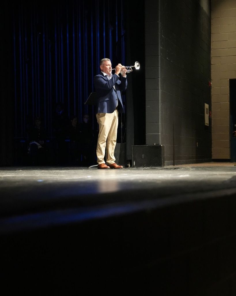 A man plays a trumpet on a stage.