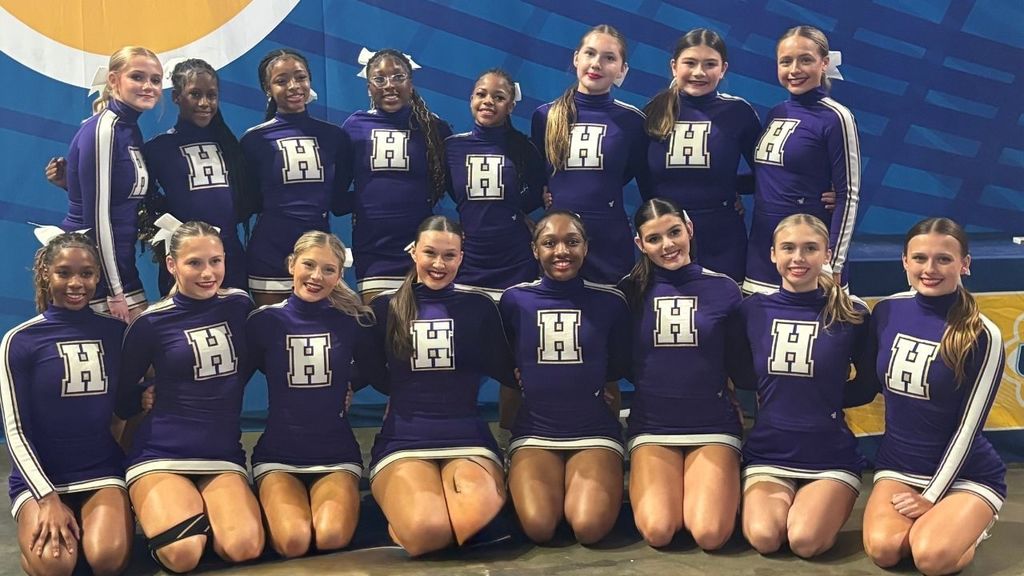 Hueytown High School cheerleaders smile and pose for a photo while at a cheer competition.