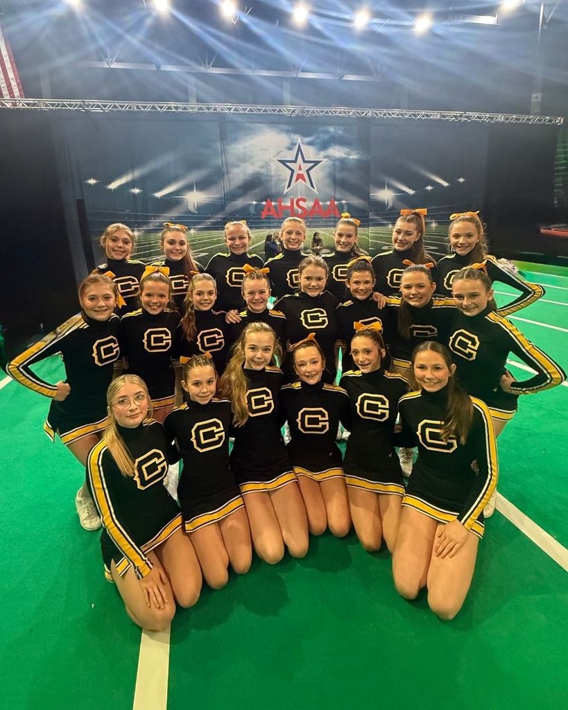 Corner Middle School cheerleaders smile and pose for a photo while at the 2025 AHSAA State Cheer Competition.