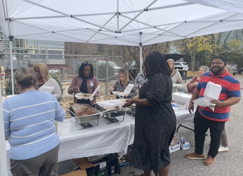 JEFCOED employees fix plates of barbecue and sides while standing under a tent in the parking lot of the Central Office Building.