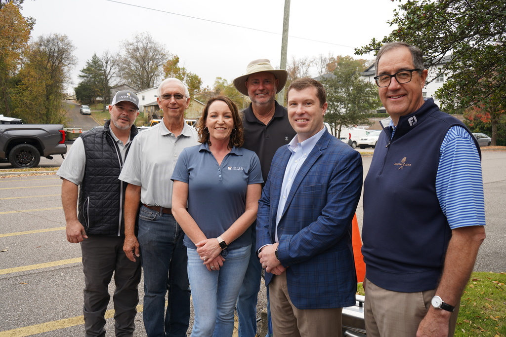 Lathan Architects employees stand togehter in a parking lot and smile for a photo.