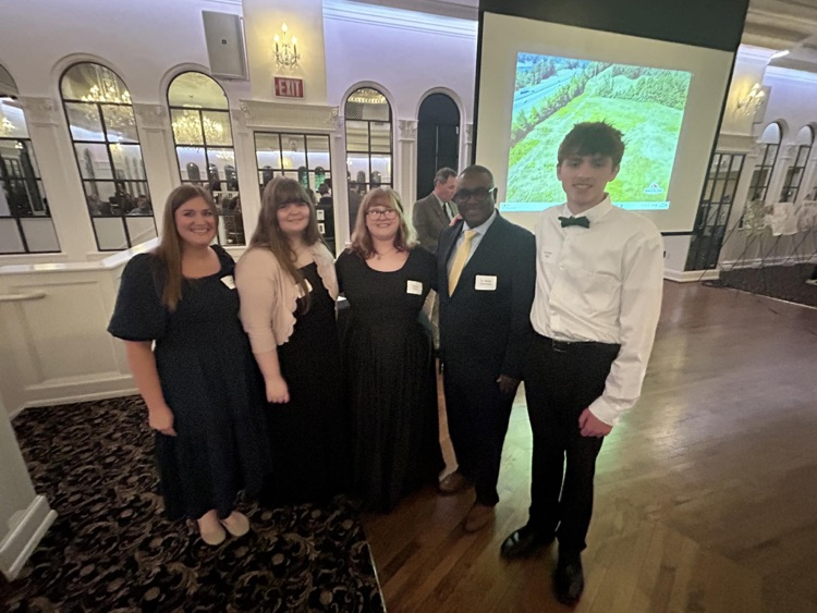 A group of students stand together in a banquet hall for a photo with JEFCOED Superintendent Dr. Gonsoulin.