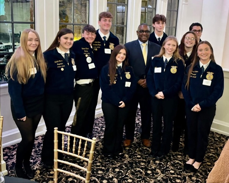 A group of students stand together in a banquet hall for a photo with JEFCOED Superintendent Dr. Gonsoulin.