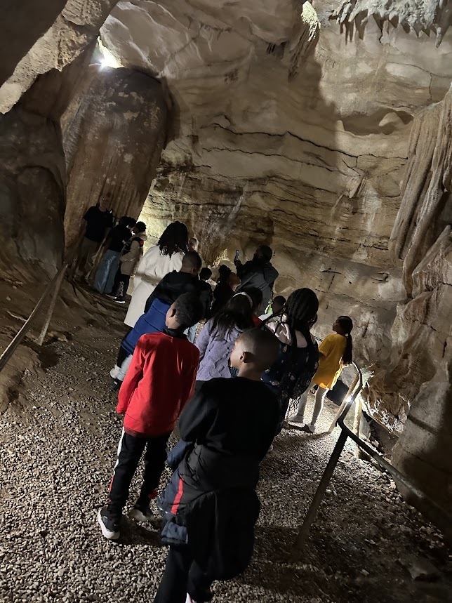 Students walk through a cave.