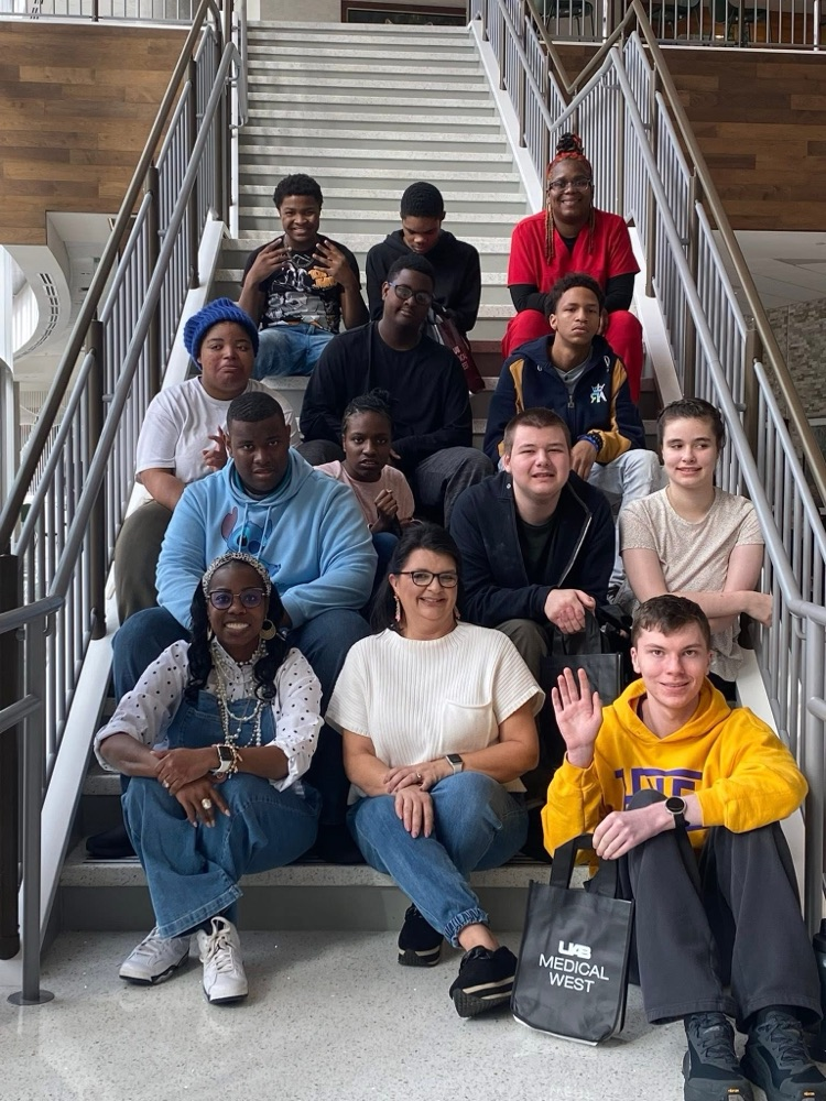 Hueytown teachers and students sit on stairs at UAB Medical West.