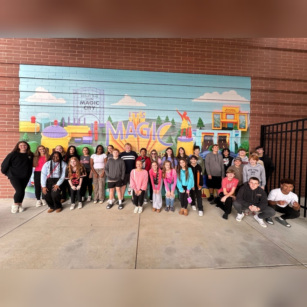 North Jefferson Middle School students stand together for a photo in front of a mural at Protective Stadium.
