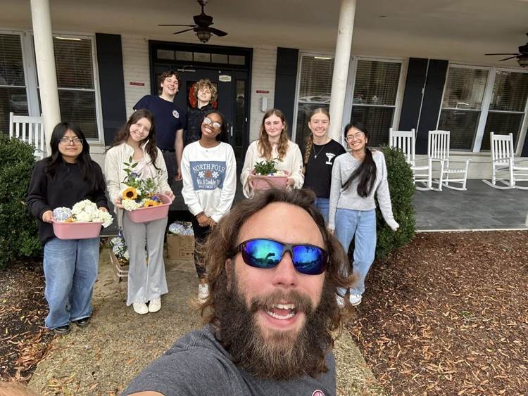 McAdory High School students and an adult stand outside a retirement community.
